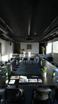 a conference room with tables and chairs and plants at Royal Blue Resort & Residences in Tivat