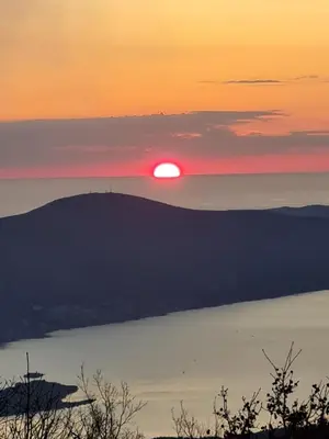 a sunset over the water with the sun in the distance at Villa Skyline in Kotor