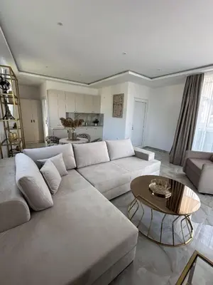 a living room with a white couch and a table at Apartments Vuksanovic in Bar