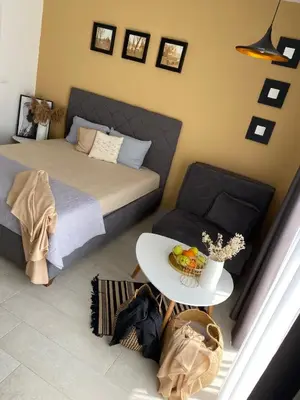 a bedroom with a bed and a table with a bowl of fruit at Apartments Vuksanovic in Bar