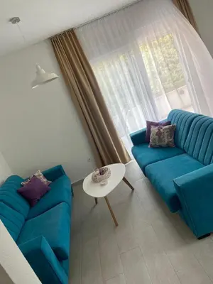 a living room with a blue couch and a table at Apartments Vuksanovic in Bar