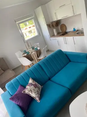 a blue couch in a living room with a table at Apartments Vuksanovic in Bar