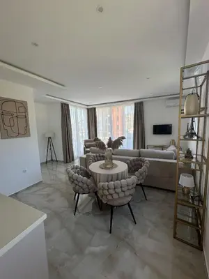 a living room with a couch and a table and chairs at Apartments Vuksanovic in Bar