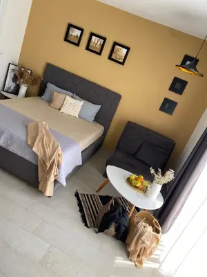 a bedroom with a bed and a table and a chair at Apartments Vuksanovic in Bar