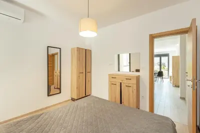 a white bedroom with a bed and a mirror at Apartment Ava in Kotor