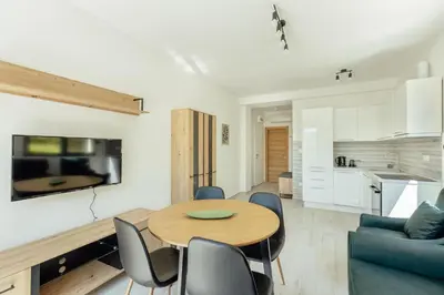 a kitchen and a dining room with a table and chairs at Apartment Ava in Kotor