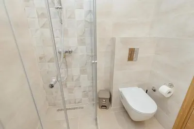 a bathroom with a toilet and a glass shower at Apartment Ava in Kotor