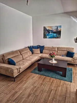 a living room with a brown couch and a table at Studios Merdović in Budva