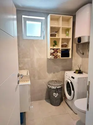 a bathroom with a sink and a washing machine at Studios Merdović in Budva