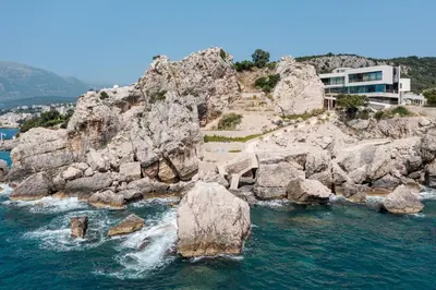a building on the side of a rocky cliff at CONTiNUUM in Ulcinj