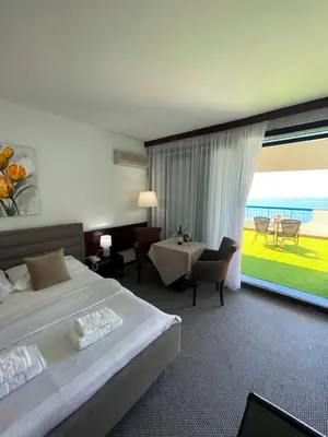 a hotel room with a bed and a large window at CORPUS A - Hotel Albatros in Ulcinj