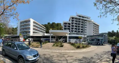 a car parked in front of a parking lot with buses at CORPUS A - Hotel Albatros in Ulcinj