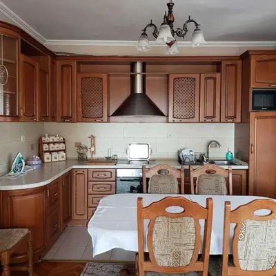 a kitchen with wooden cabinets and a table and chairs at City Center Two-Bedroom Apartment in Ulcinj
