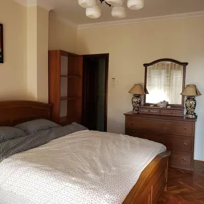 a bedroom with a bed and a mirror and a dresser at City Center Two-Bedroom Apartment in Ulcinj