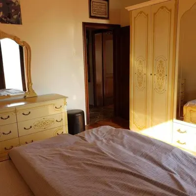 a bedroom with a bed and a dresser and a mirror at City Center Two-Bedroom Apartment in Ulcinj