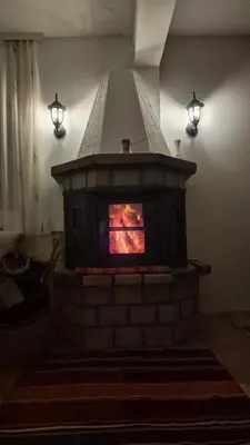 a brick fireplace with a stove in a room at Gazdinstvo Đurović in Dobra Voda