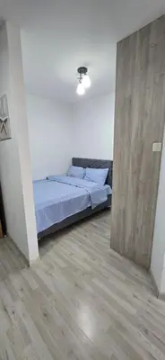 a bedroom with a bed and a wooden floor at Stan apartman Lana Budva in Budva