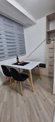 a dining room with a white table and chairs at Stan apartman Lana Budva in Budva