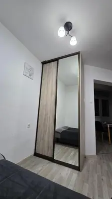 a mirror in a room with a bed and a bedroom at Stan apartman Lana Budva in Budva