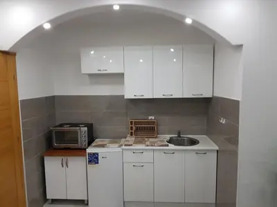 a white kitchen with a sink and a microwave at Apartmani MINA in Bar