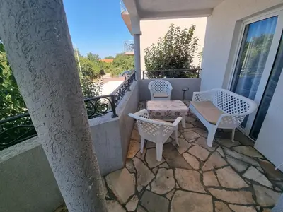 a patio with two chairs and a table on a balcony at Apartmani MINA in Bar