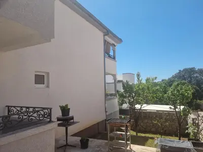 a balcony of a white building with a table and chairs at Apartmani MINA in Bar