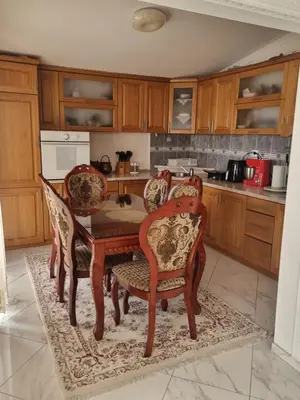 a kitchen with a wooden table and chairs at Apartmani MINA in Bar