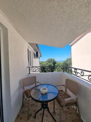 a table and chairs on a balcony with a view at Apartmani MINA in Bar