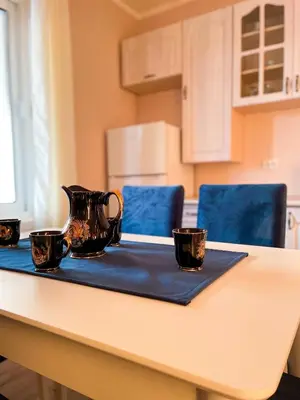 a tea kettle on a table with three cups on it at Apartman 200 in Ulcinj