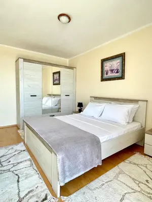 a bedroom with a large white bed and a mirror at Apartman 200 in Ulcinj