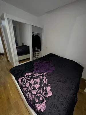 a bedroom with a bed with a purple blanket at Laura apartment City kvart in Podgorica