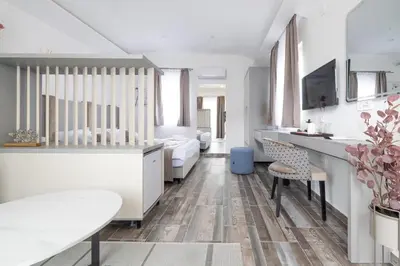a white room with a dining table and chairs at Hotel Reset in Budva