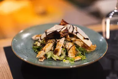 a plate of food with a salad on a table at Hotel Reset in Budva