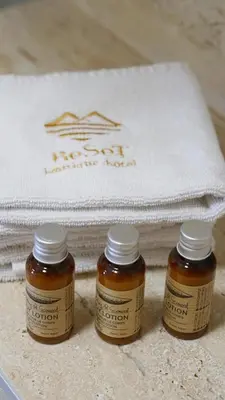 two bottles of honey sitting next to a towel at Hotel Reset in Budva