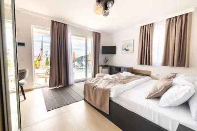 a bedroom with a large bed and a balcony at Hotel Reset in Budva