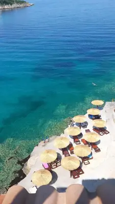 a group of chairs and umbrellas on a beach at Apartments Misko in Utjeha