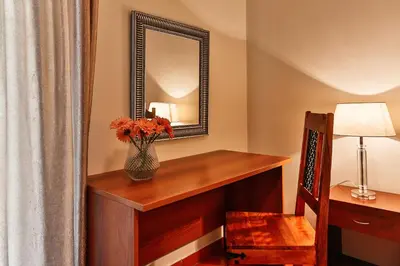 a room with a desk with a mirror and a vase with flowers at Apartments Misko in Utjeha