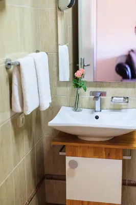 a bathroom with a sink and a vase with a flower at Apartments Misko in Utjeha