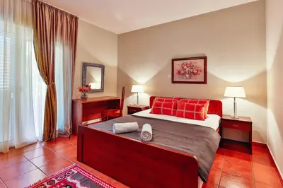 a bedroom with a large bed with red pillows at Apartments Misko in Utjeha