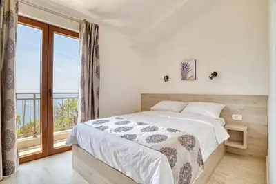 a bedroom with a bed and a large window at Seaview Villa Lavanda with pool in Budva