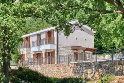 a house on a stone wall with trees at Seaview Villa Lavanda with pool in Budva