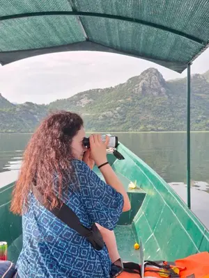 a woman taking a picture on a boat on the water at Apartment Dapcevic Skadar lake in Vranjina