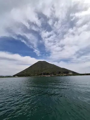 a mountain in the middle of a body of water at Apartment Dapcevic Skadar lake in Vranjina