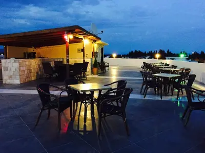 a group of tables and chairs on a patio at night at Guesthouse Liamra in Ulcinj