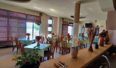 a dining room with tables and chairs in a restaurant at Guesthouse Liamra in Ulcinj