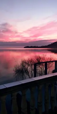 a sunset over a body of water with a fence at Apartments Nikola in Bar