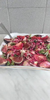 a plate of fruit and vegetables on a table at Apartments Nikola in Bar