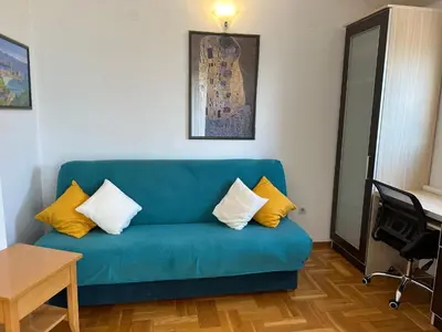 a blue couch with yellow pillows in a living room at Wonder Apartments in Budva