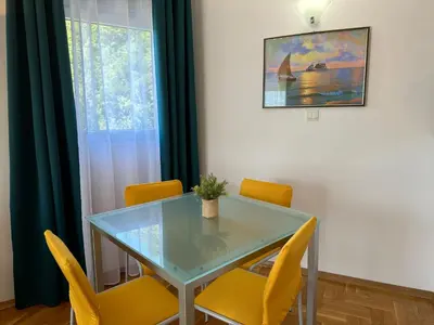 a dining room with a glass table and yellow chairs at Wonder Apartments in Budva