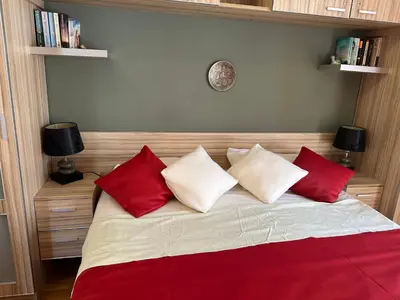 a bedroom with a bed with red and white pillows at Wonder Apartments in Budva